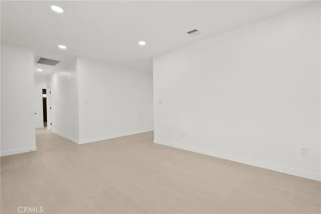 a view of a big room with wooden floor a ceiling fan and windows