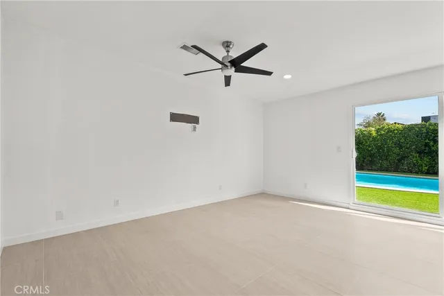 an empty room with a ceiling fan and a window