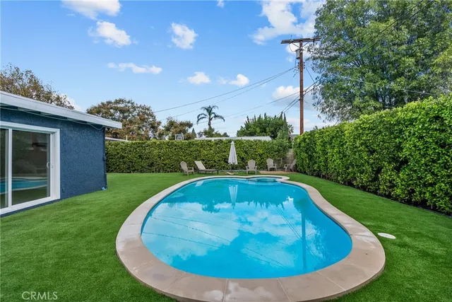 a view of backyard with barbeque grill and wooden fence