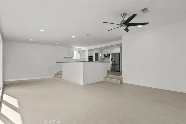 a view of a kitchen with a refrigerator and white cabinets