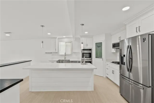 a kitchen with stainless steel appliances a refrigerator sink and cabinets