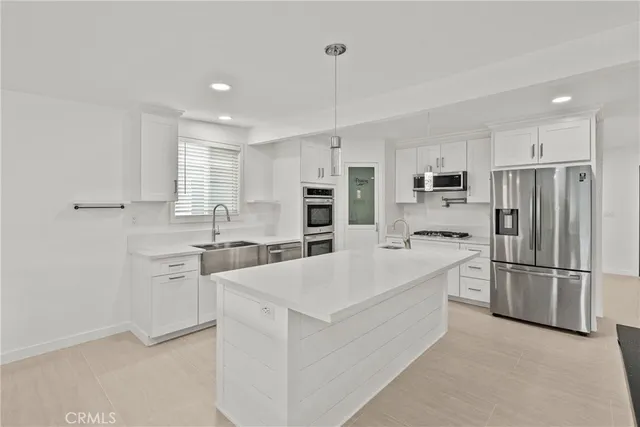 a large white kitchen with cabinets and stainless steel appliances