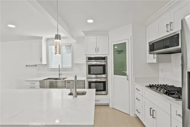 a kitchen with stainless steel appliances granite countertop a refrigerator and a stove top oven