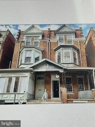 a kitchen with a refrigerator a sink and wooden floor
