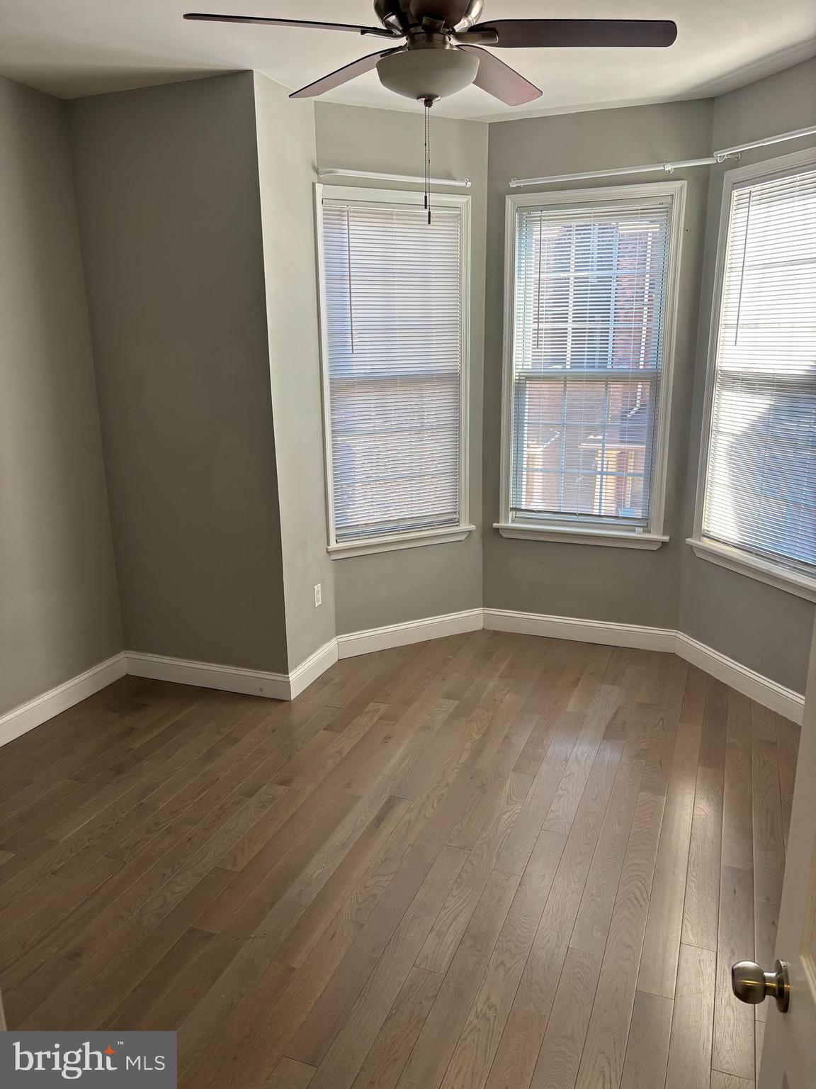 216 Buckingham Place, Unit 2 Philadelphia, PA 19104 - Photo 14 of 18 an empty room with wooden floor and windows