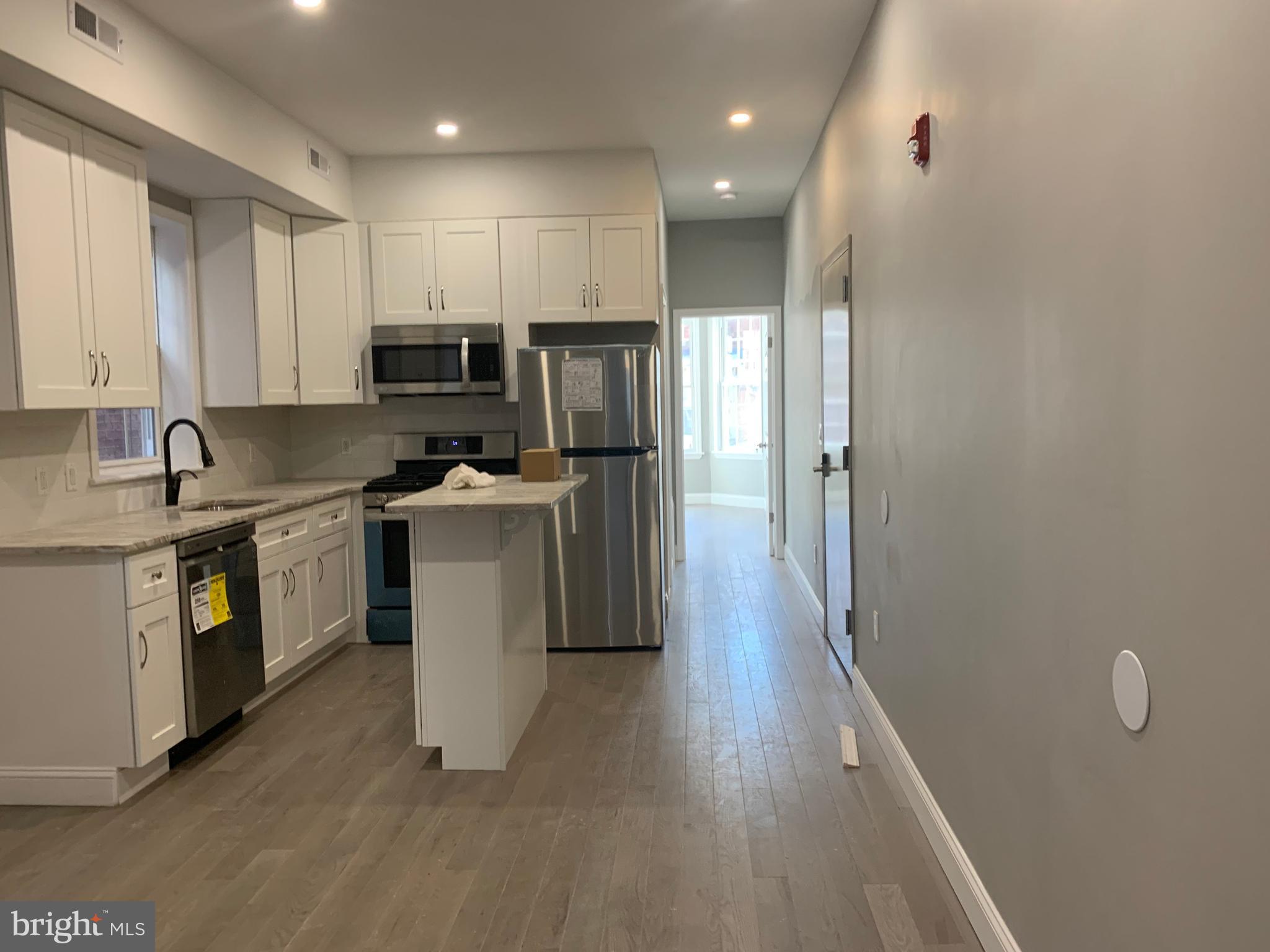 216 Buckingham Place, Unit 2 Philadelphia, PA 19104 - Photo 2 of 18 a kitchen with a refrigerator a sink and wooden floor