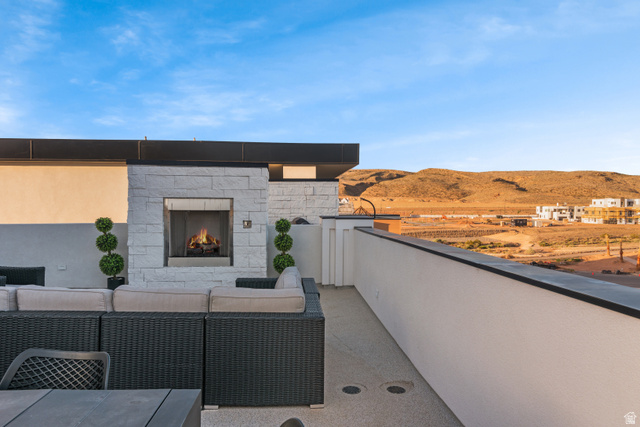 5367 Cyan Lane St. George, UT 84790 - Photo 37 of 49 Rooftop patio with a white stone fireplace and a built-in outdoor kitchen area
