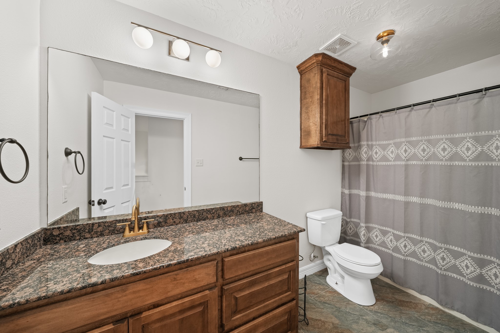 6101 Fox Ridge Drive Angleton, TX 77515 - Photo 24 of 30 a bathroom with a granite countertop toilet sink and mirror