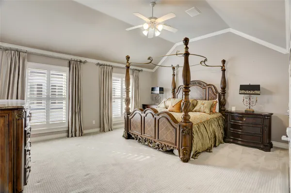 a bedroom with a bed ceiling fan and a window