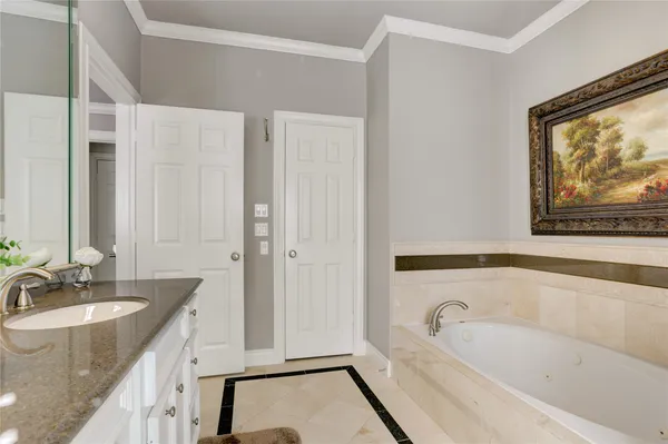 a bathroom with a granite countertop tub sink and mirror