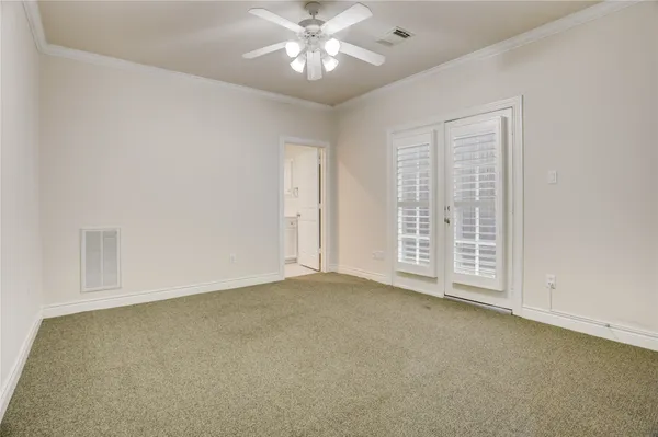 a view of an empty room with chandelier fan and fire place