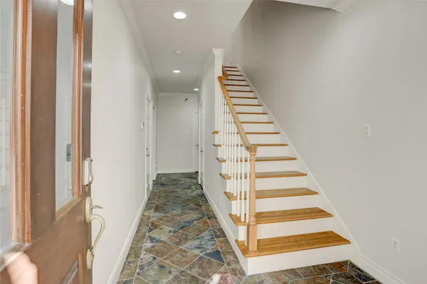 a view of a hallway with wooden floor and entryway