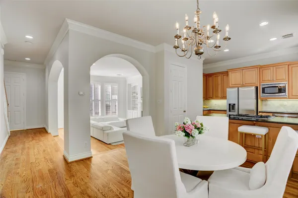 a view of a dining room with furniture a chandelier and wooden floor