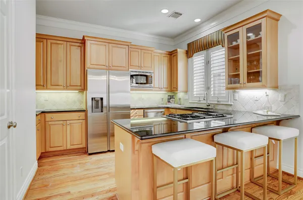 a kitchen with stainless steel appliances granite countertop a stove a sink and a refrigerator