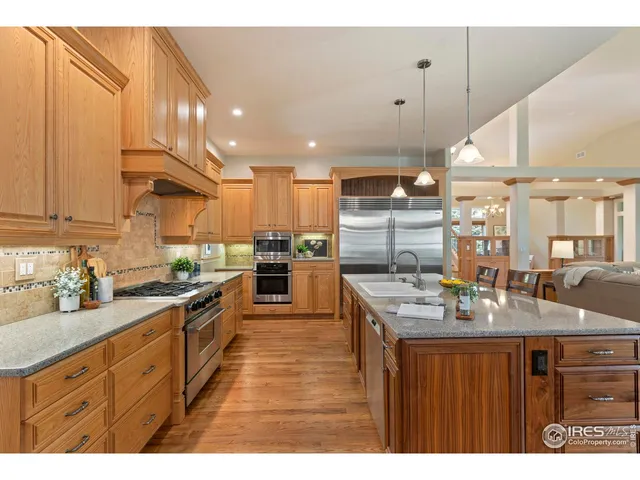 a kitchen with stainless steel appliances granite countertop wooden cabinets a stove a sink and a refrigerator