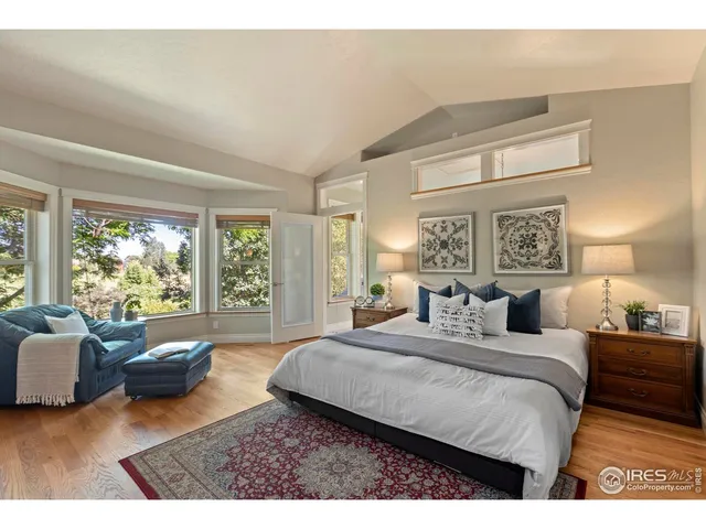 a bedroom with a bed couch and a large window