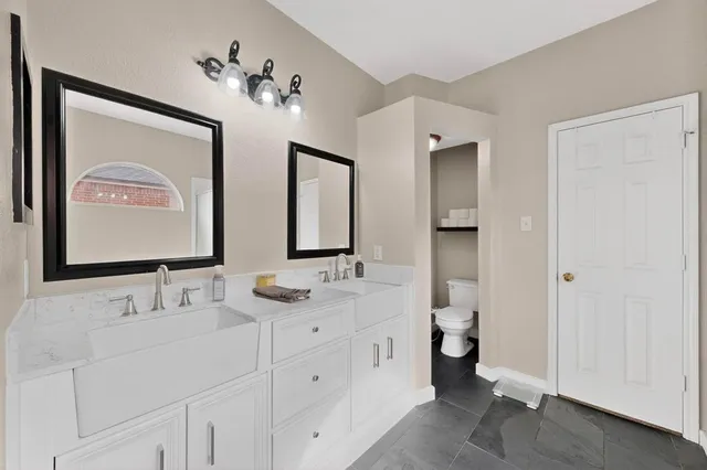 a bathroom with double vanity sinks a mirror and a shower