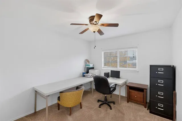 a view of a workspace with furniture and a window
