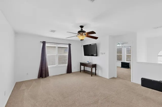 a view of a livingroom with a flat screen tv kitchen and chandelier