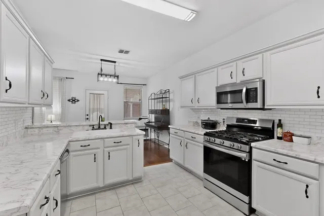 a kitchen with stainless steel appliances granite countertop a sink and stove top oven