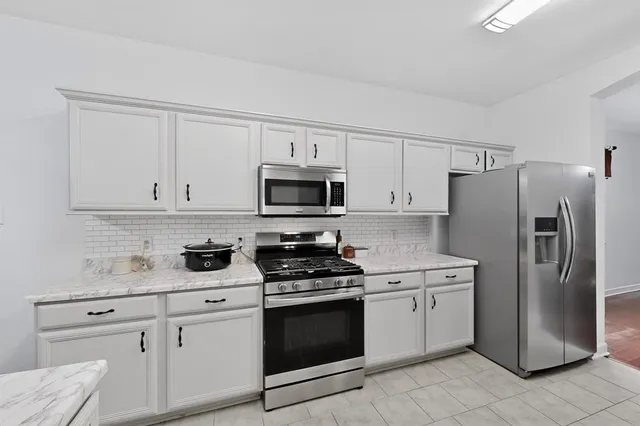 a kitchen with white cabinets stainless steel appliances and sink