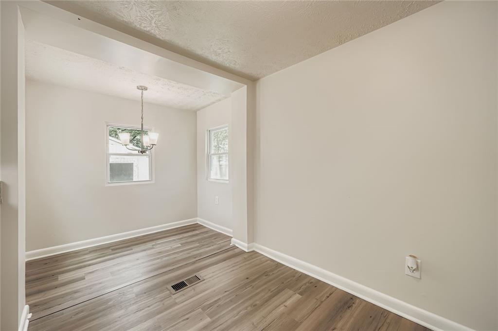 6678 Collier Way Riverdale, GA 30296 - Photo 13 of 29 an empty room with wooden floor and windows