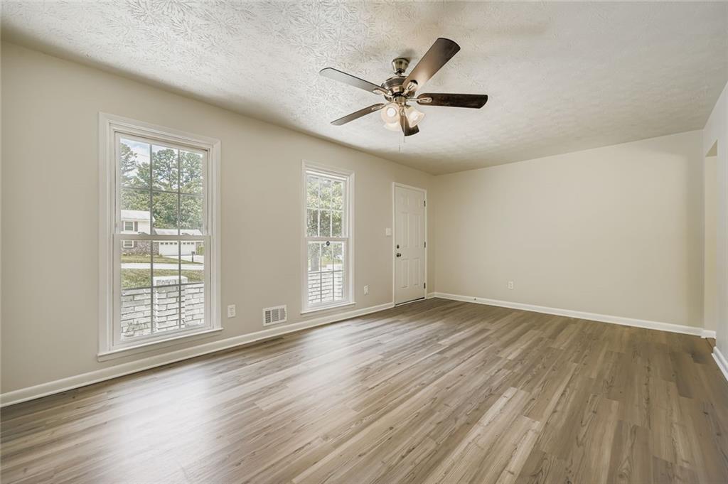 6678 Collier Way Riverdale, GA 30296 - Photo 7 of 29 a view of an empty room with wooden floor and a window