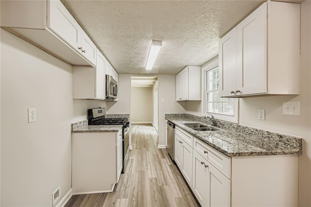 6678 Collier Way Riverdale, GA 30296 - Photo 10 of 29 a kitchen with a stove sink and cabinets