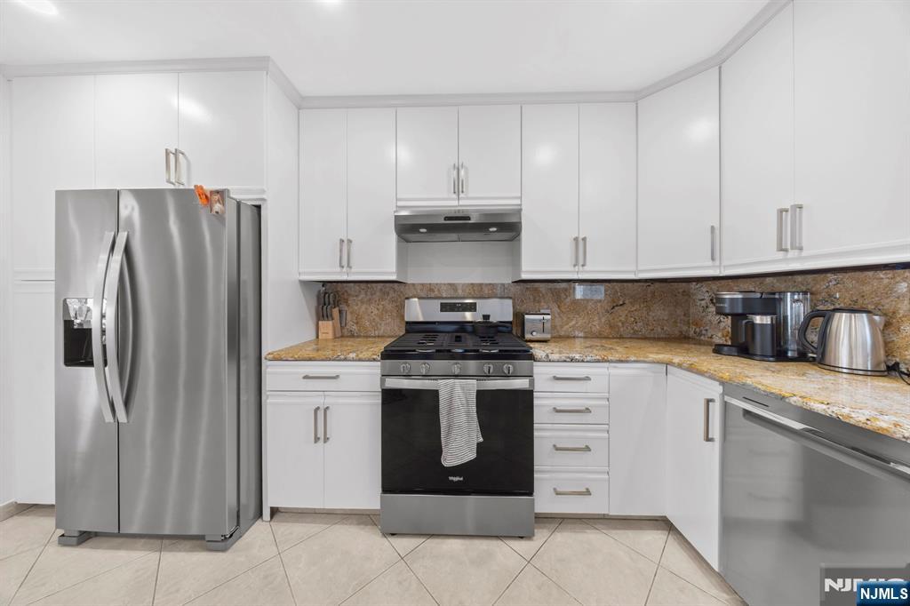 62 Sycamore Road Dumont, NJ 07628 - Photo 8 of 43 a kitchen with granite countertop stainless steel appliances and white cabinets