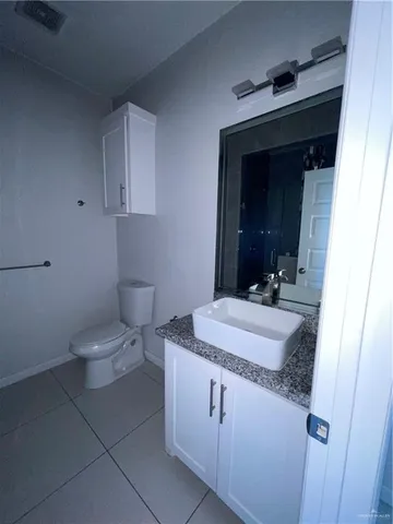 a bathroom with a granite countertop sink a toilet and mirror