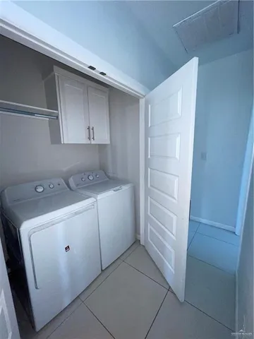 a utility room with cabinets washer and dryer