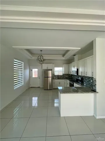 a view of a kitchen with kitchen island and stainless steel appliances