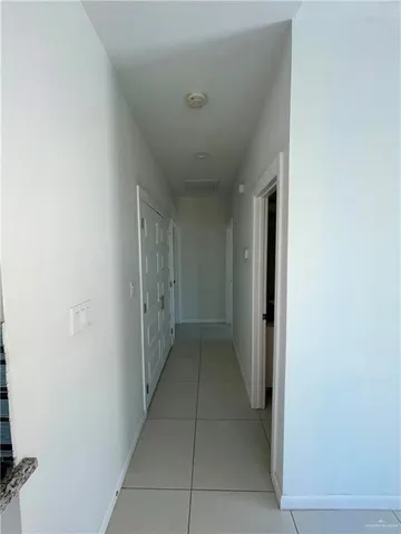 a view of hallway with a window and a refrigerator