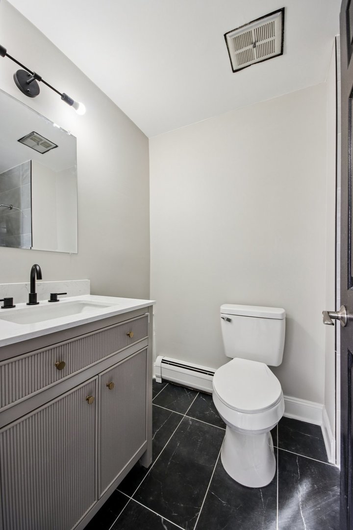 1111 Bloomingdale Road, Unit 2A Glendale Heights, IL 60139 - Photo 14 of 26 a bathroom with a toilet sink and mirror