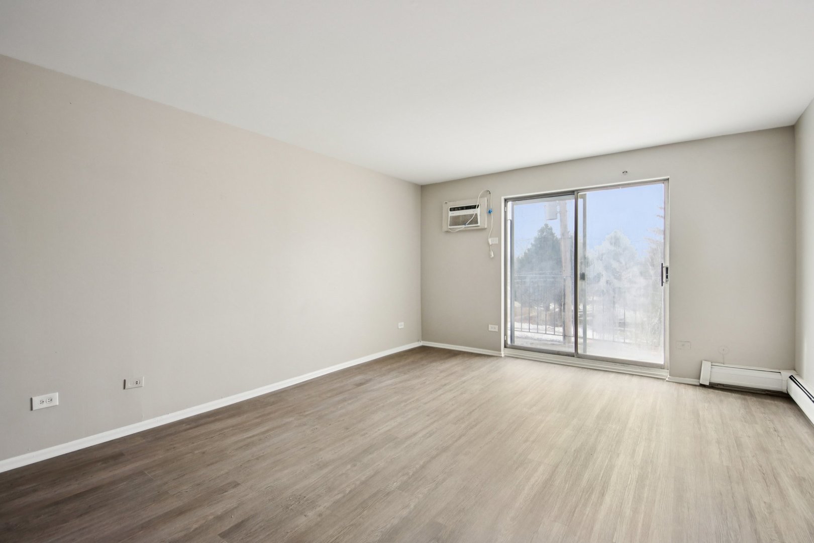 1111 Bloomingdale Road, Unit 2A Glendale Heights, IL 60139 - Photo 3 of 26 an empty room with wooden floor and windows