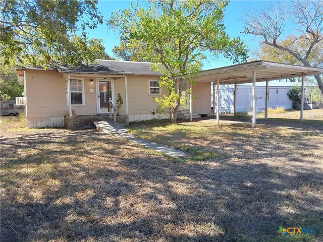 a view of a house with backyard and sitting area