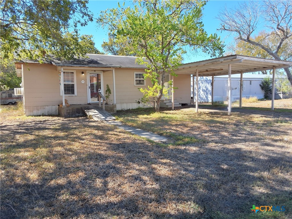a view of a house with backyard and sitting area