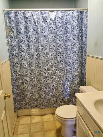 a white toilet sitting next to a shower curtain