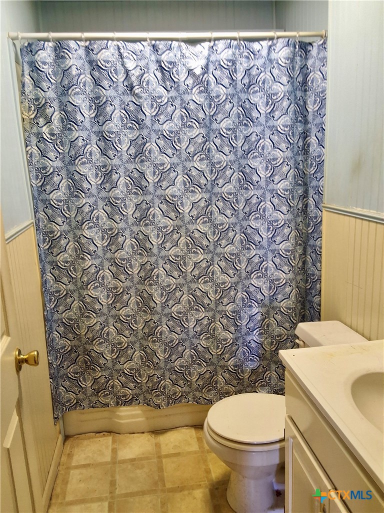 609 East Sarah Street Cuero, TX 77954 - Photo 9 of 14 a white toilet sitting next to a shower curtain