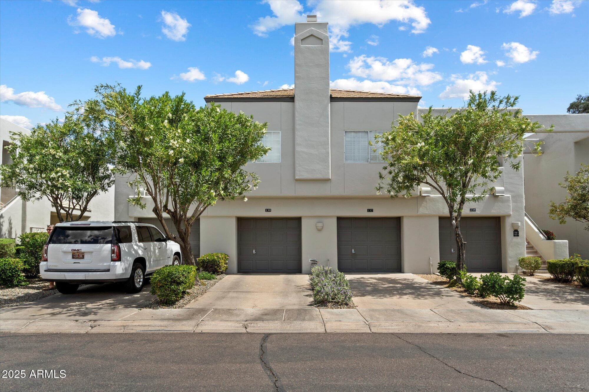 7710 East Gainey Ranch Road, Unit 139 Scottsdale, AZ 85258 - Photo 10 of 38 a front view of a house with a garden
