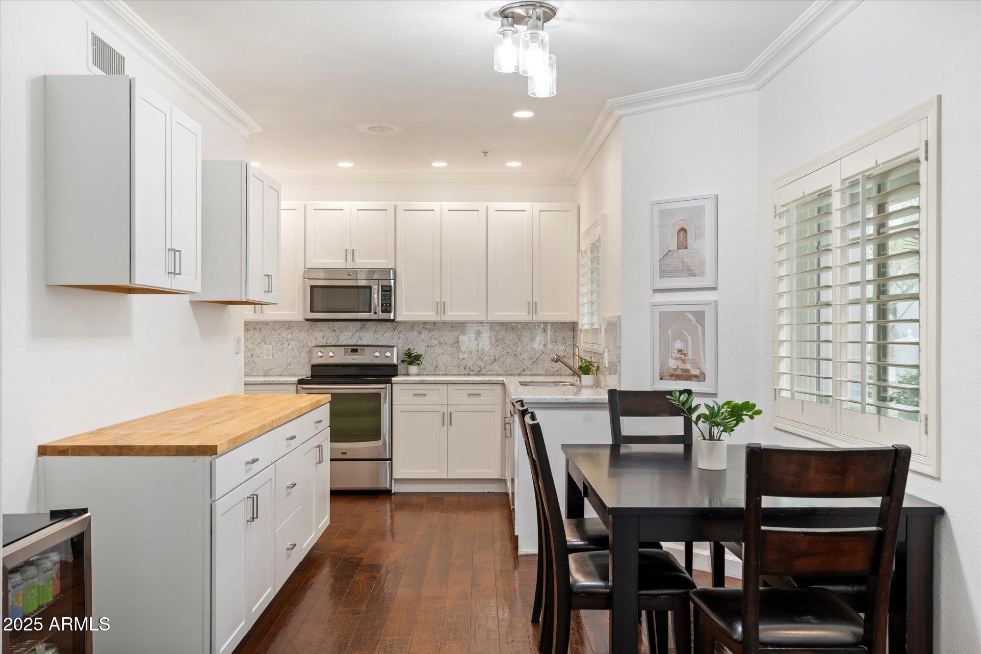 7710 East Gainey Ranch Road, Unit 139 Scottsdale, AZ 85258 - Photo 14 of 38 a kitchen with a white cabinets and chairs