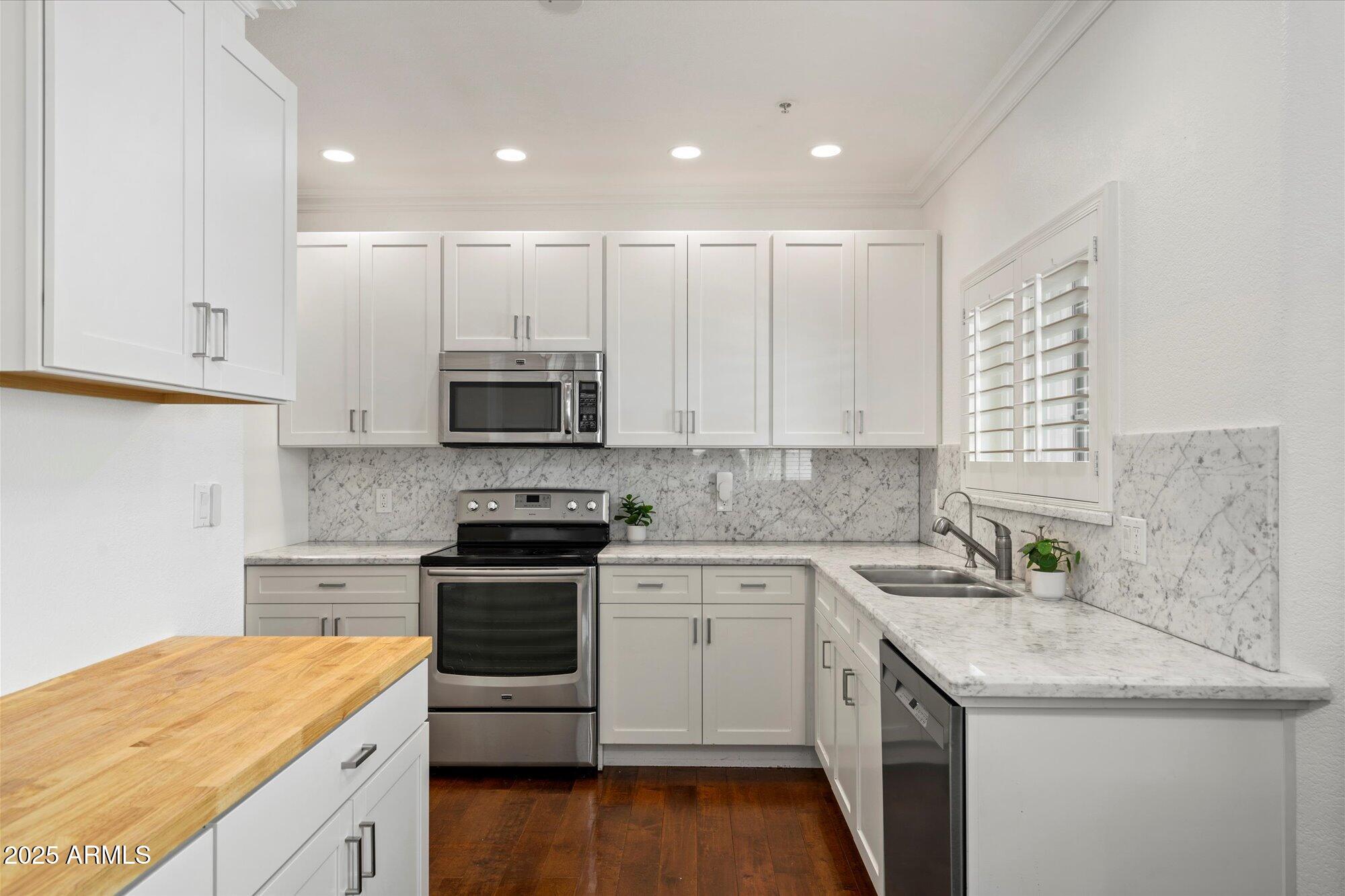 7710 East Gainey Ranch Road, Unit 139 Scottsdale, AZ 85258 - Photo 15 of 38 a kitchen with a sink stove and cabinets