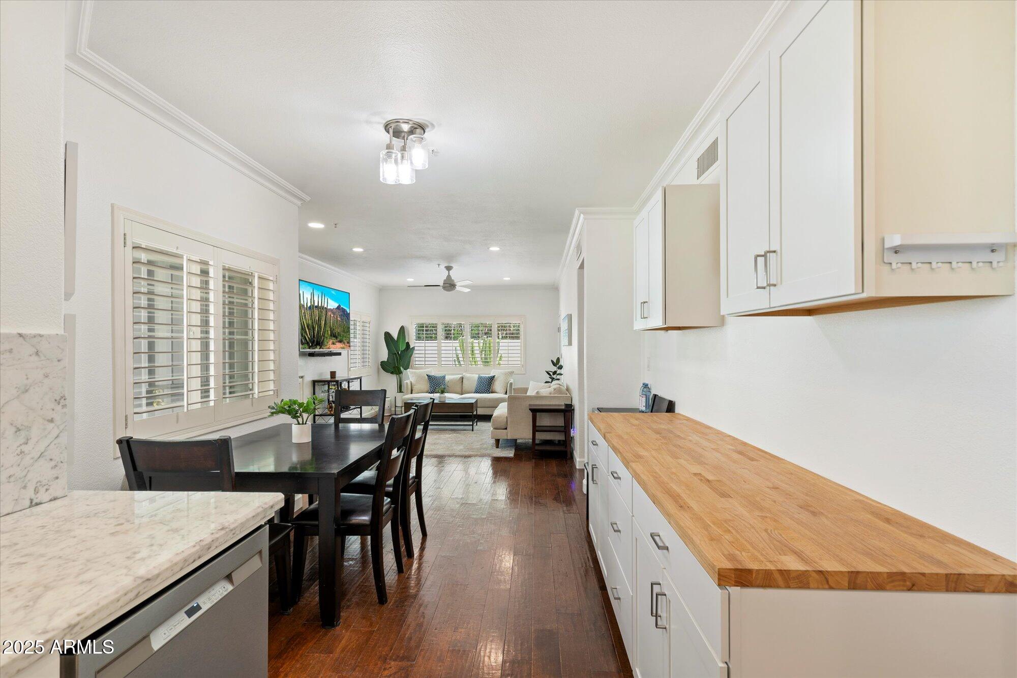 7710 East Gainey Ranch Road, Unit 139 Scottsdale, AZ 85258 - Photo 17 of 38 a kitchen with stainless steel appliances granite countertop sink microwave and wooden floor