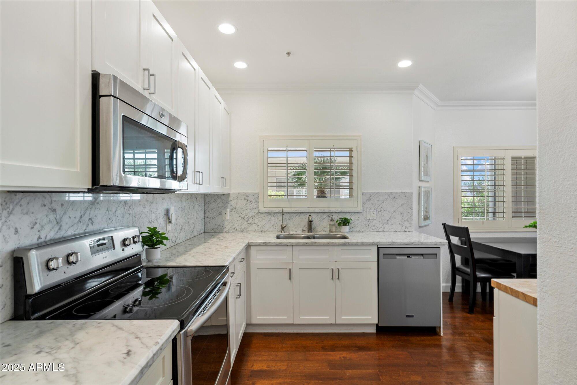 7710 East Gainey Ranch Road, Unit 139 Scottsdale, AZ 85258 - Photo 18 of 38 a kitchen that has a sink a stove and cabinets