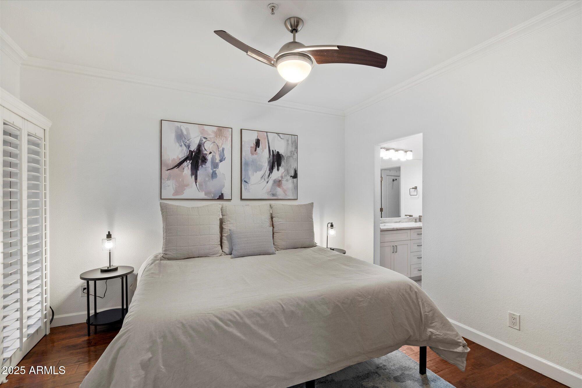 7710 East Gainey Ranch Road, Unit 139 Scottsdale, AZ 85258 - Photo 19 of 38 a bedroom with a large bed and a chandelier