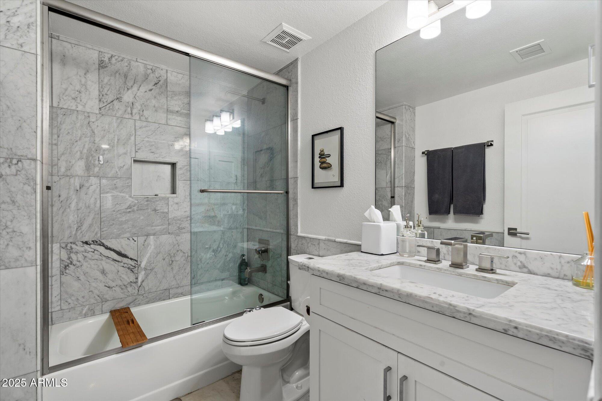 7710 East Gainey Ranch Road, Unit 139 Scottsdale, AZ 85258 - Photo 24 of 38 a bathroom with a granite countertop sink toilet and shower