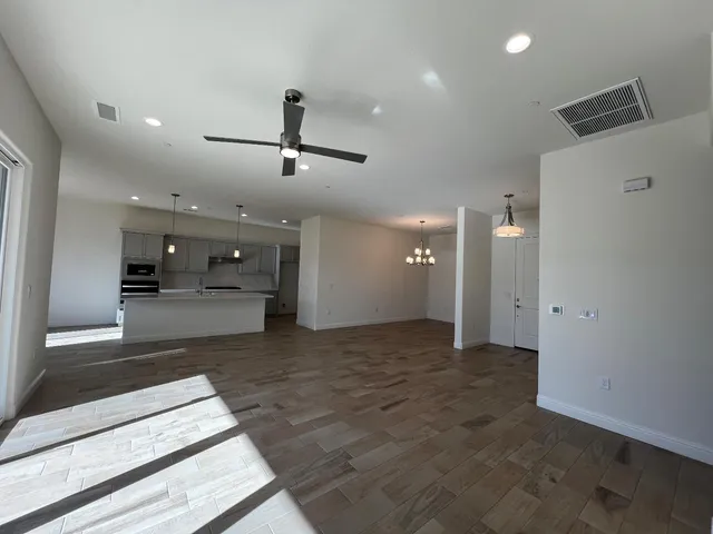 a view of a kitchen with kitchen island a sink stainless steel appliances and cabinets