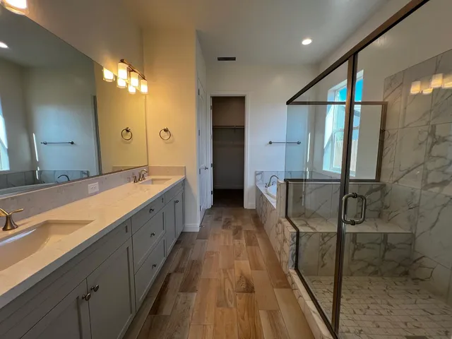 a bathroom with a tub a sink and a mirror