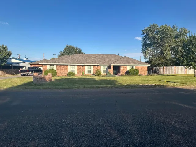 a big yard with table and chairs under an umbrella
