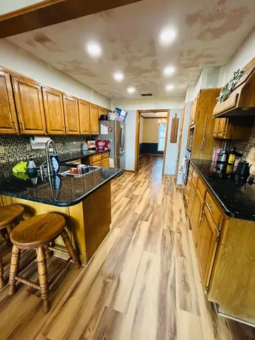 a kitchen with stainless steel appliances granite countertop a sink stove and cabinets